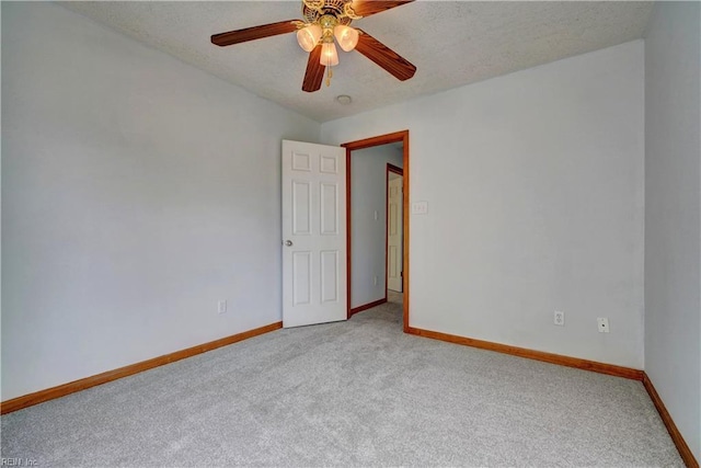 carpeted spare room featuring ceiling fan and a textured ceiling