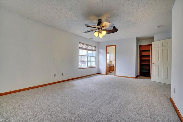 carpeted spare room with ceiling fan and a textured ceiling