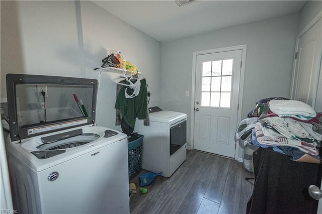 laundry room with washing machine and dryer and dark wood-type flooring