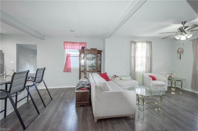 living room featuring a wealth of natural light, dark hardwood / wood-style flooring, beamed ceiling, and ceiling fan