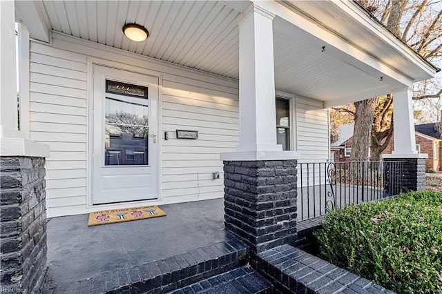 view of exterior entry featuring covered porch