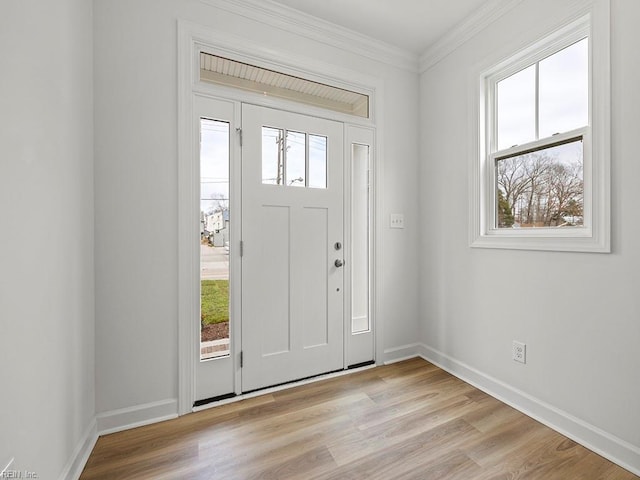 foyer entrance with light hardwood / wood-style floors and crown molding