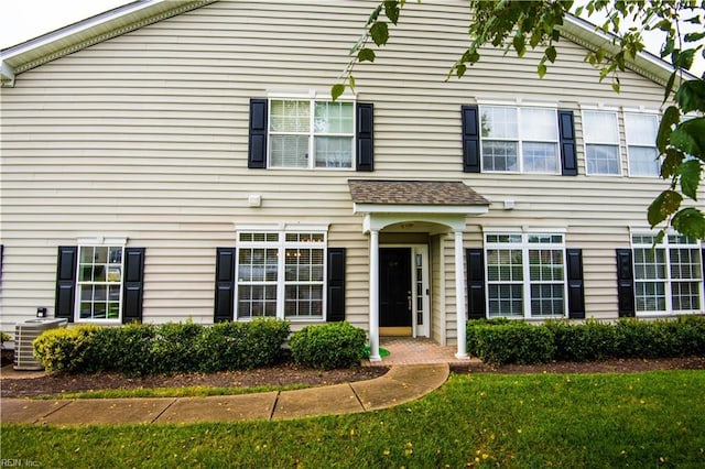 view of front of house featuring a front lawn and cooling unit