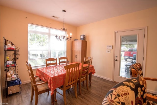 dining area featuring a notable chandelier, plenty of natural light, and dark hardwood / wood-style flooring