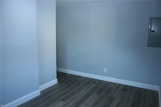 empty room featuring electric panel and dark hardwood / wood-style flooring