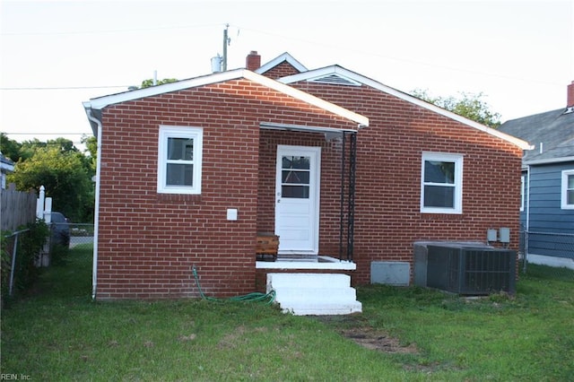 rear view of house featuring a yard and central AC unit