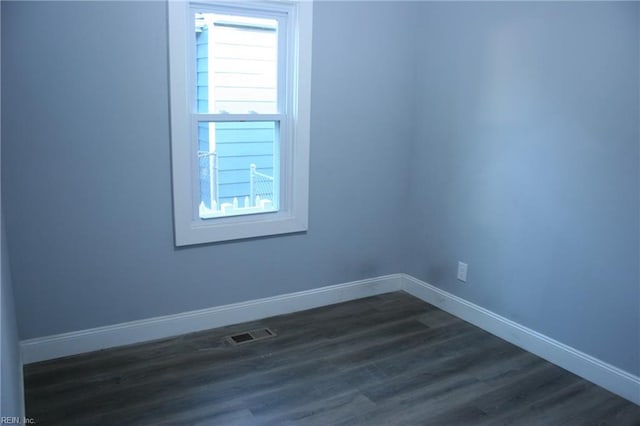 spare room with dark wood-type flooring