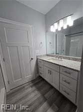 bathroom featuring wood-type flooring, vanity, and walk in shower