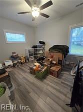 interior space featuring hardwood / wood-style flooring, ceiling fan, and multiple windows