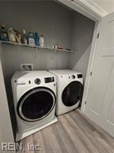 laundry area featuring washer and clothes dryer and light hardwood / wood-style flooring