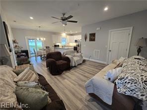 living room featuring hardwood / wood-style floors and ceiling fan with notable chandelier