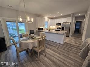 dining room with dark hardwood / wood-style flooring and a notable chandelier