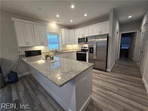 kitchen with kitchen peninsula, white cabinets, and appliances with stainless steel finishes