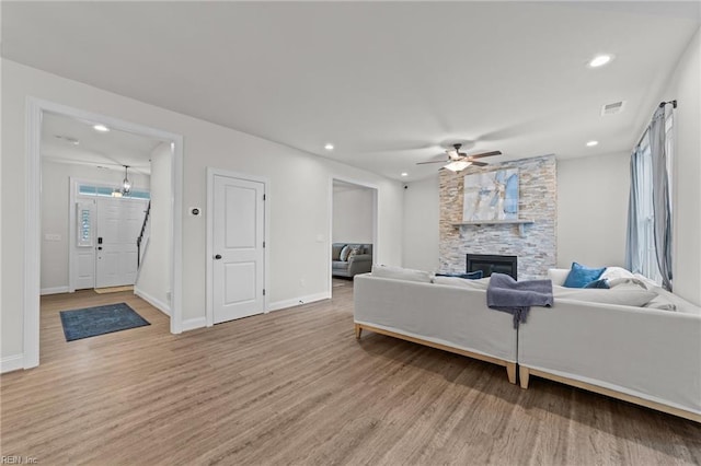 living room with ceiling fan, a fireplace, and wood-type flooring