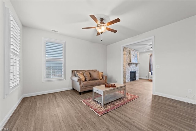 living room featuring a fireplace, ceiling fan, and hardwood / wood-style floors