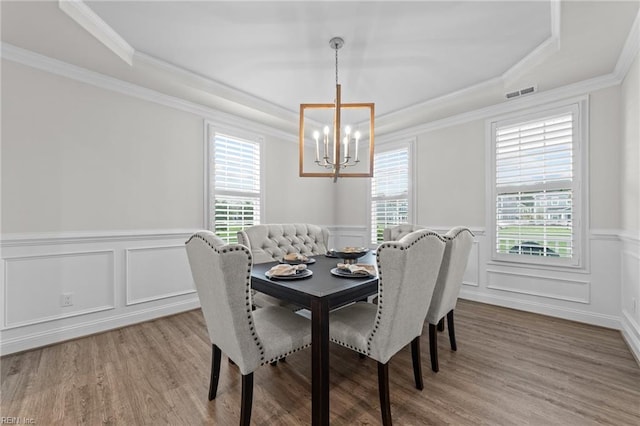 dining room featuring crown molding, plenty of natural light, an inviting chandelier, and light hardwood / wood-style flooring