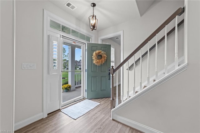 entrance foyer with light wood-type flooring and an inviting chandelier