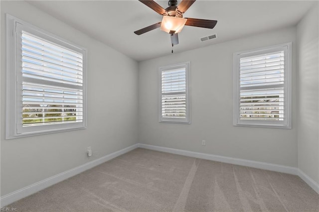 spare room featuring ceiling fan and light colored carpet