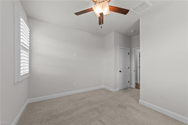 unfurnished room with light colored carpet and ceiling fan