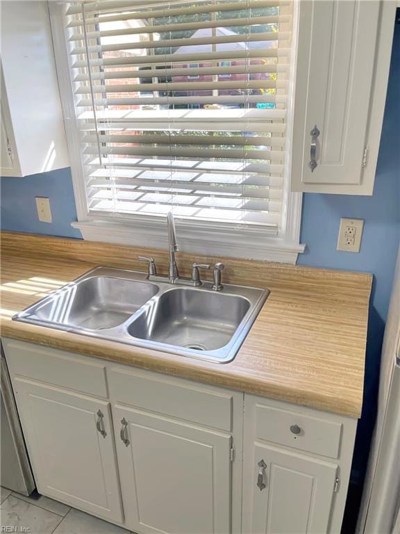 kitchen featuring white cabinetry, sink, and a healthy amount of sunlight