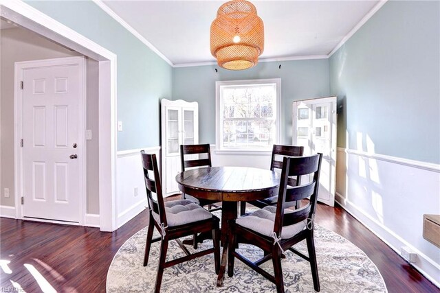 dining space with ornamental molding and dark wood-type flooring