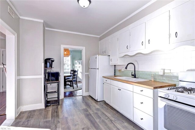 kitchen with light wood-type flooring, ornamental molding, white appliances, sink, and white cabinetry