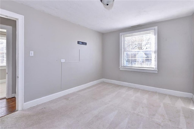 unfurnished room featuring light carpet