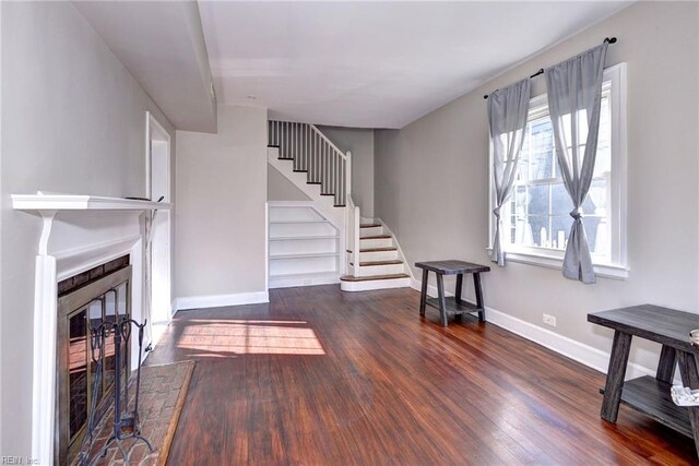 living room with a fireplace and dark wood-type flooring