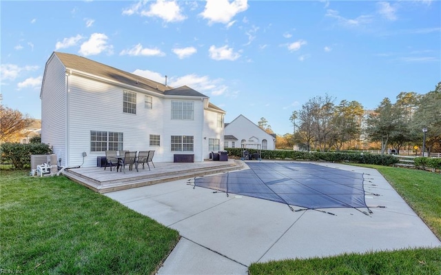 view of swimming pool featuring a patio, a wooden deck, and a lawn