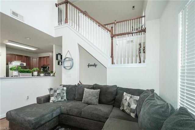 living room featuring hardwood / wood-style floors and a towering ceiling