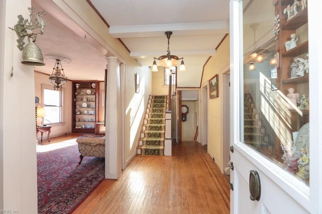 interior space featuring beamed ceiling, wood-type flooring, and a notable chandelier