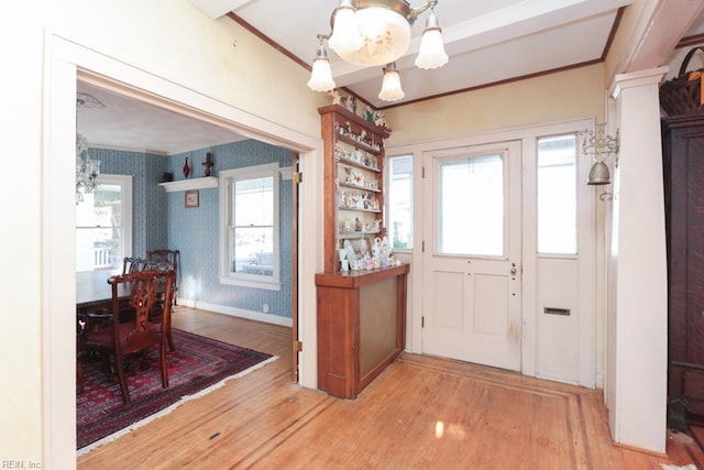 entrance foyer with light hardwood / wood-style floors and a chandelier