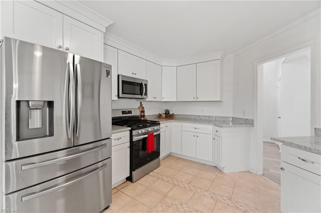 kitchen with light stone countertops, white cabinetry, crown molding, and stainless steel appliances