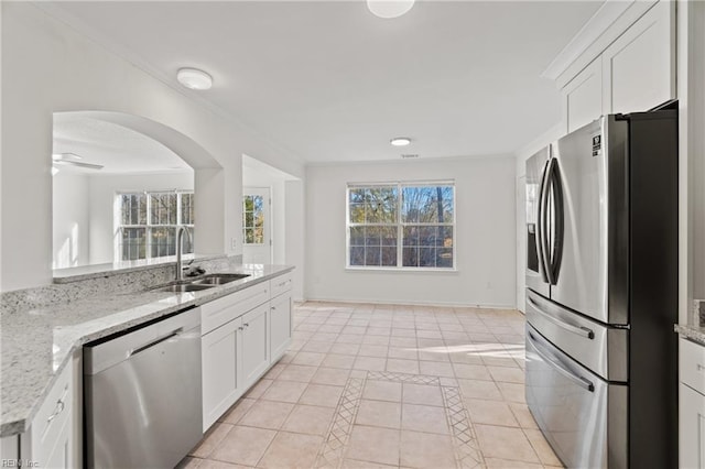 kitchen with white cabinetry, sink, light stone counters, and appliances with stainless steel finishes