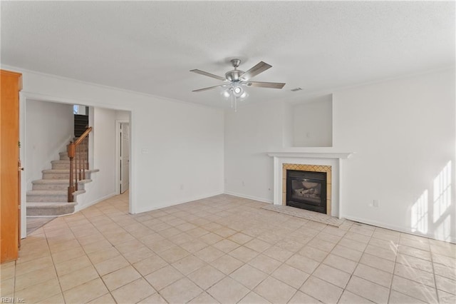 unfurnished living room featuring ceiling fan, a fireplace, and light tile patterned flooring