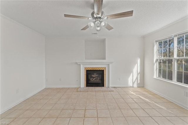 unfurnished living room with ceiling fan, light tile patterned flooring, a textured ceiling, and a tile fireplace