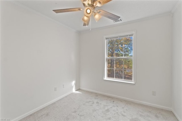 empty room with ceiling fan, crown molding, and light carpet