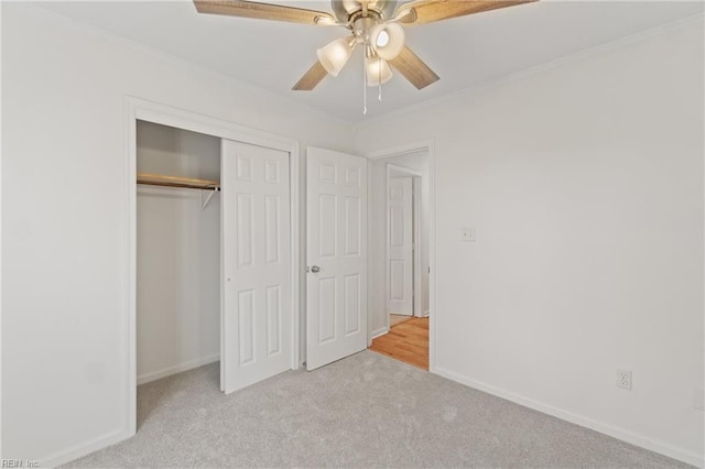 unfurnished bedroom with light carpet, a closet, ceiling fan, and ornamental molding