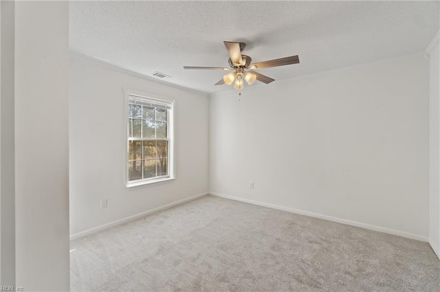 spare room featuring light carpet, ceiling fan, and a textured ceiling