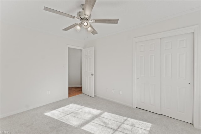 unfurnished bedroom featuring light carpet, a closet, and ceiling fan