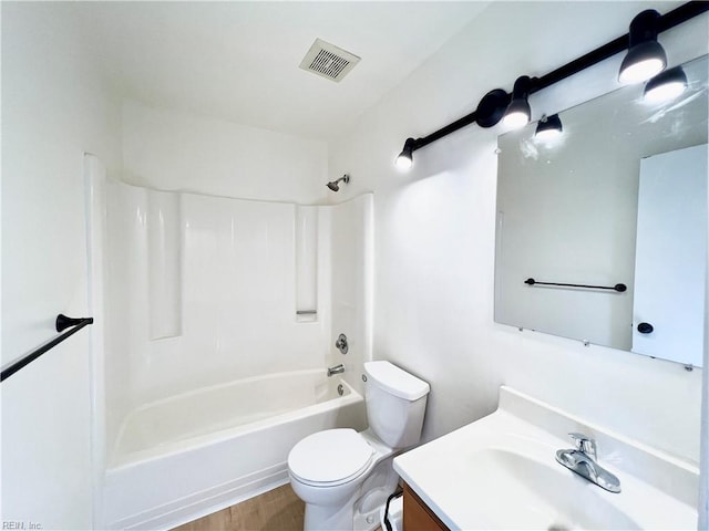 full bathroom with washtub / shower combination, hardwood / wood-style floors, vanity, and toilet