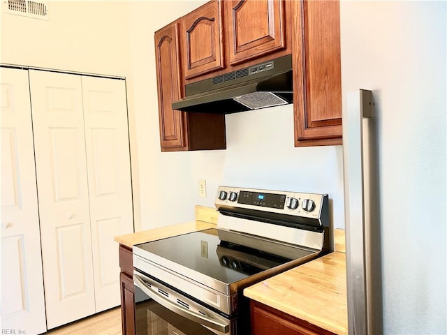 kitchen with electric range and light hardwood / wood-style floors