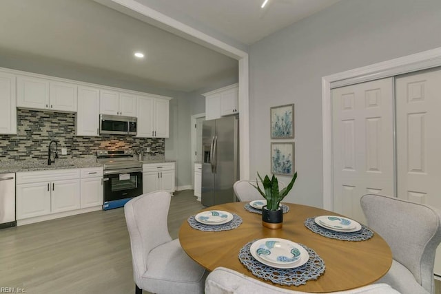 dining space featuring light hardwood / wood-style flooring and sink