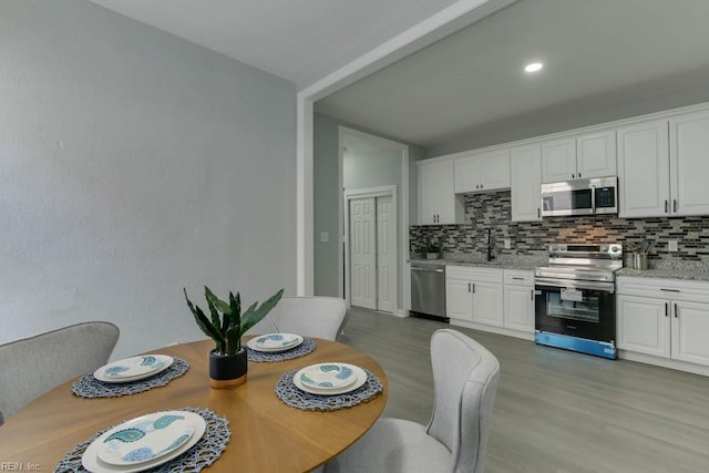 dining space with light hardwood / wood-style flooring and sink