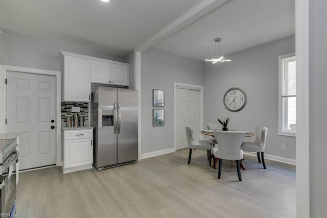 kitchen with backsplash, white cabinets, light hardwood / wood-style flooring, appliances with stainless steel finishes, and light stone counters