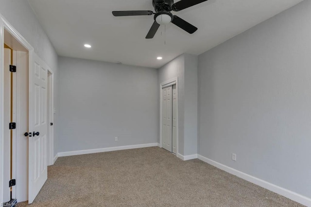 unfurnished bedroom featuring a closet, light colored carpet, and ceiling fan