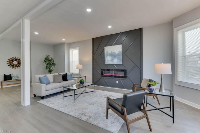 living room with a large fireplace and light hardwood / wood-style floors