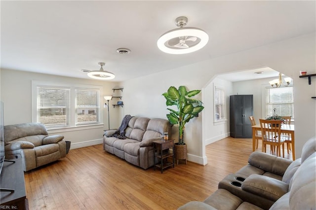 living room with a chandelier and light wood-type flooring