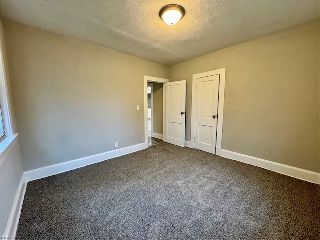 unfurnished bedroom with a textured ceiling and carpet floors