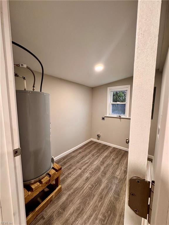 laundry area with electric dryer hookup, gas water heater, and dark wood-type flooring